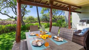 uma mesa com comida no pátio em ORCHID VILLA Inviting Fairways 3BR with Bikes and Private Beach Club em Waikoloa