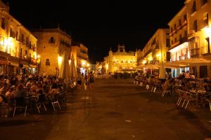 a group of people sitting in chairs on a street at night at Casa Rural La Cenicienta in Sancti Spíritus