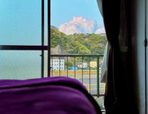 een raam met uitzicht op een berg bij 酒と宿と不動産-yado- in Yokosuka