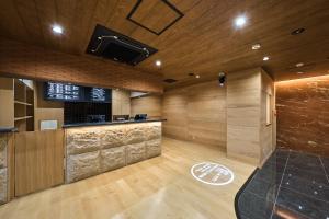 a room with a bar and a tv on the wall at Sauna & Capsule Hotel Rumor Plaza in Kyoto