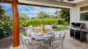 a patio with a table and chairs and a grill at TROPICAL BREEZES Stunning Views from KaMilo 3BR Home Walk to Beach in Waikoloa