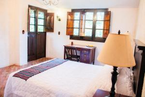 a bedroom with a bed with a lamp and a desk at Finca Ana Isabel 