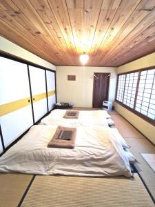 een groot bed in een kamer met ramen bij Mt Fuji Historical Oshi house hitsuki in Fujiyoshida