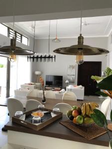 Luxury Villas at Royal Park في بالاكلافا: غرفة معيشة مع طاولة مع وعاء من الفواكه