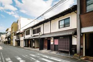an empty street in an asian city with buildings at Hatoba an Machiya House in Kyoto
