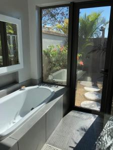 baño con bañera grande y ventana en Luxury Villas at Royal Park en Balaclava