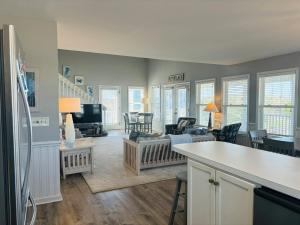 a living room with a kitchen and a living room with a couch at Long Grass in Holden Beach +64 photos