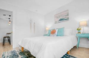 een witte slaapkamer met een bed en een blauw bureau bij Beachside Suite, Newly Renovated, Steps to the Sand, Relax and Unwind! in St. Augustine