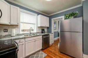 a kitchen with white cabinets and a stainless steel refrigerator at All Seasons Cottage - Game Room - Firepit By Zen Living Short Term Rental in Luray
