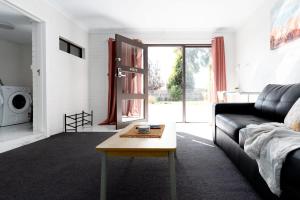 ein Wohnzimmer mit einem Sofa und einem Couchtisch in der Unterkunft Riverside Gem with Parking & WiFi in Alanvale