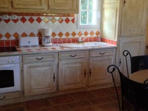 a kitchen with wooden cabinets and a sink and a window at Gîte de Caractère avec Piscine Privée dans Parc Arboré Proche Châteaux de la Loire - FR-1-491-376 in Angé +6 photos