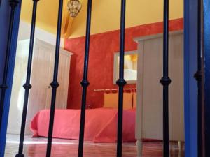 a bedroom with a bed with a red bedspread at Gîte de Caractère avec Piscine Privée dans Parc Arboré Proche Châteaux de la Loire - FR-1-491-376 in Angé