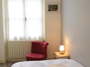 Un dormitorio con una silla roja y una cama en Gîte Sargé-sur-Braye, 4 pièces, 6 personnes - FR-1-491-385, en Sargé-sur-Braye