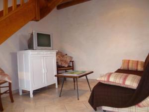 a living room with a tv and a bed and a table at Charmante maison avec jardin clos à Cour-Cheverny, animaux acceptés - FR-1-491-387 in Cour-Cheverny