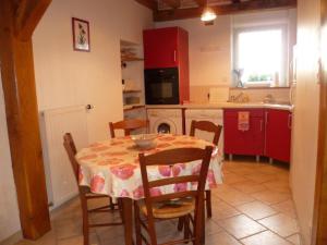 a kitchen with a table and chairs and red cabinets at Maison de charme avec jardin clos, animaux acceptés, près de Cheverny, tout confort inclus - FR-1-491-387 in Cour-Cheverny