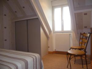 a bedroom with a bed and a chair and a window at Maison de charme avec jardin clos, animaux acceptés, près de Cheverny, tout confort inclus - FR-1-491-387 in Cour-Cheverny