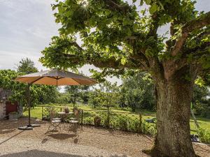 a table and an umbrella next to a tree at Gîte champêtre avec jardin, jeux pour enfants, animaux bienvenus - FR-1-491-390 in Cour-Cheverny