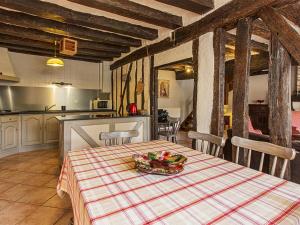 a kitchen with a table with a bowl of fruit on it at Gîte champêtre avec jardin, jeux pour enfants, animaux bienvenus - FR-1-491-390 in Cour-Cheverny