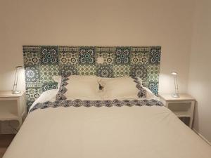 a bedroom with a large white bed with two lamps at Gîte confortable près de Chambord avec jardin et parking - FR-1-491-410 in Muides-sur-Loire
