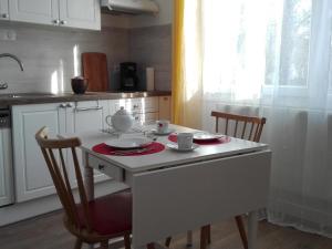 a kitchen with a table with two chairs and a tea set at Gîte confortable près de Chambord avec jardin et parking - FR-1-491-410 in Muides-sur-Loire