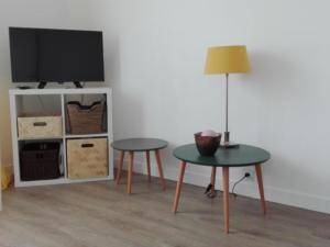 a living room with two tables and a tv at Gîte confortable près de Chambord avec jardin et parking - FR-1-491-410 in Muides-sur-Loire