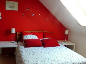1 dormitorio con paredes rojas y 1 cama con almohadas rojas en Gîte Couddes, 3 pièces, 6 personnes - FR-1-491-411, en Couddes