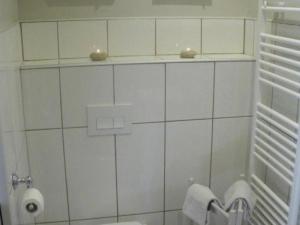 a white tiled bathroom with a toilet and towels at Gîte Monteaux, 2 pièces, 2 personnes - FR-1-491-422 in Monteaux