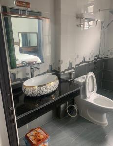 a bathroom with a sink and a toilet and a mirror at Khách Sạn Hùng Trang Hotel in Tam Ðảo