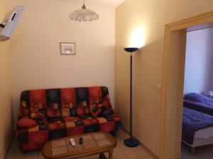 a living room with a couch and a lamp at Ancienne maison de maître rénovée, 6 pers, au cœur de la Sologne avec cour fermée et équipements modernes - FR-1-491-412 in Souvigny-en-Sologne