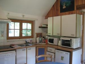 a kitchen with white appliances and a sink at Maison solognote avec étang privé, barque, pêche gratuite et vélos inclus, proche Saint-Viâtre - FR-1-491-416 in Saint-Viâtre