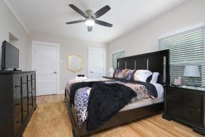 ein Schlafzimmer mit einem Bett und einem Deckenventilator in der Unterkunft The Marbled Speakeasy - San Antonio Luxury Home by the Alamo in San Antonio