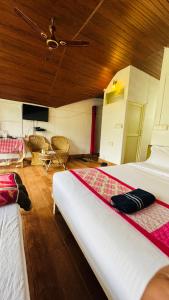 een slaapkamer met 2 bedden en een plafond bij Coorg Heritage Hill View Resort in Madikeri