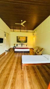 two beds in a room with wooden floors at Coorg Heritage Hill View Resort in Madikeri