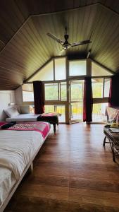 a bedroom with two beds and a ceiling fan at Coorg Heritage Hill View Resort in Madikeri