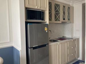 a kitchen with a refrigerator and a microwave at room in Nong Prue