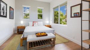 a bedroom with a bed and two windows at SUN RAY RETREAT Ocean Sunsets Views Optional Mauna Kea Hotel Privileges in Waimea