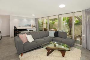 a living room with a couch and a glass table at Noosa Harbour Resort in Noosa Heads