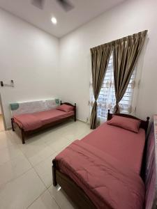 a bedroom with two beds and a window at Live Well Homestay Senawang in Seremban