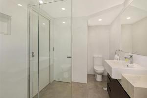 a bathroom with a shower and a sink and a toilet at Noosa Harbour Resort in Noosa Heads