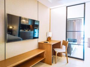 ヌサドゥアにあるMorich Nusa Dua Suite Baliの壁に大型の薄型テレビが取り付けられた部屋