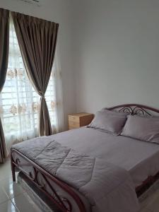 a bedroom with a bed and a window with curtains at Live Well Homestay Senawang in Seremban