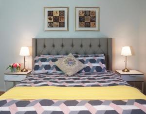 1 dormitorio con 1 cama con 2 lámparas y manta amarilla en Designer Decor Home with 8Beds at Williams Landing, en Laverton
