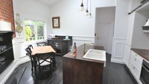 a kitchen with a sink and a table with chairs at Juniper Corner-Hunter Valley-A Step back in time!-7 mins to Vineyards in Cessnock