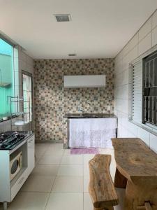 a kitchen with a counter and a table in it at Apto c Garagem próx Petrobrás e Fiat 194 2. in Betim