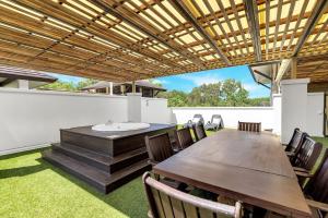 an outdoor dining room with a table and chairs at 'Tropical Escape' Coastal Daydreams with Rooftop Spa in Palm Cove