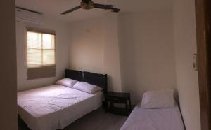 a bedroom with two beds and a ceiling fan at Apt 311 Mar de leva in Santa Marta