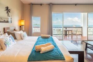 een slaapkamer met een groot bed en uitzicht op de oceaan bij Emeraude Villas - Bay in Le François