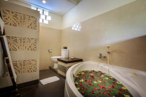 a bathroom with a bath tub and a toilet at Nang Ade Villa by Pramana Villas in Ubud