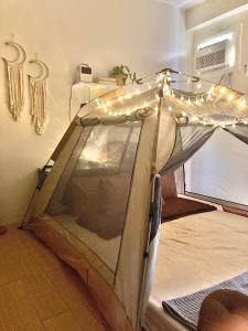 een tent met verlichting op de vloer in een kamer bij Condo Glamping at Vinia in Manilla