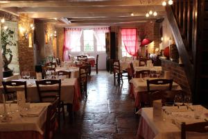 a dining room with tables and chairs in a restaurant at Hotel le Vauxois in Vaux-sous-Aubigny